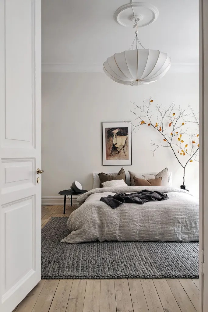 white-bedroom-with-artwork-and-faux-plant