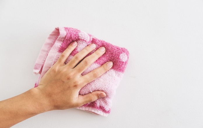 Person wiping the wall with a pink cloth